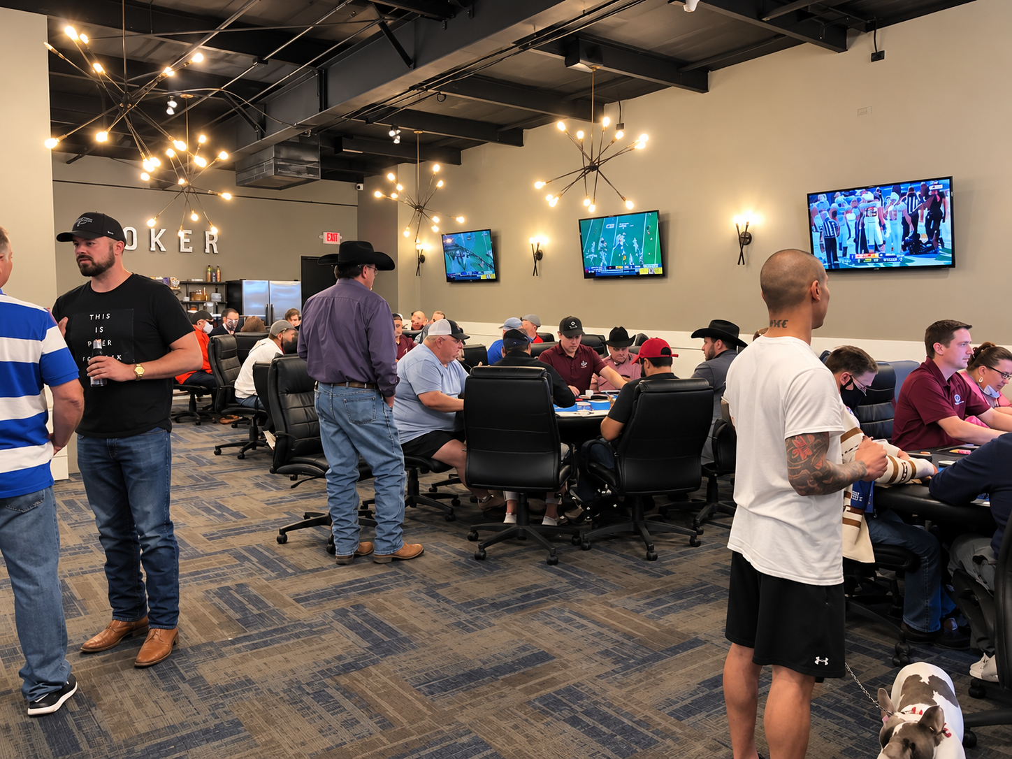 A busy poker room with people playing cards and gathering around the tables